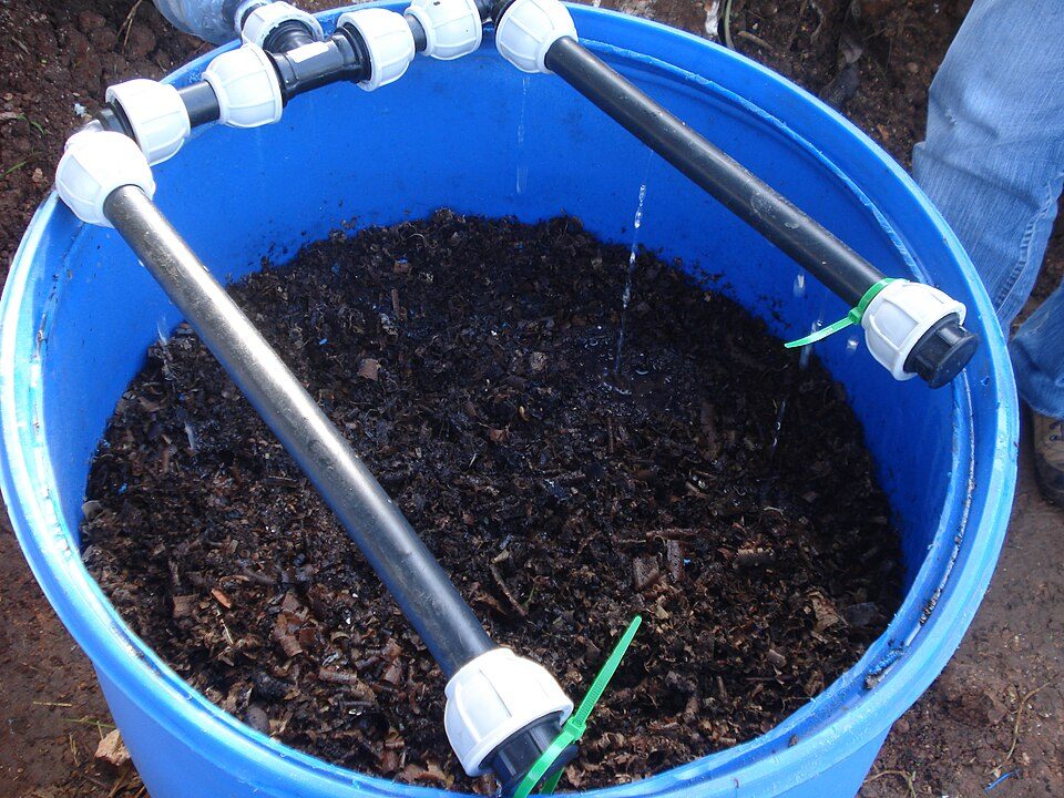 Blue barrel compost bin with pvc drip irrigation system.